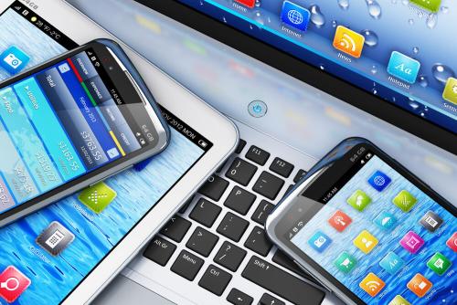 phones and tablets on laptop keyboard